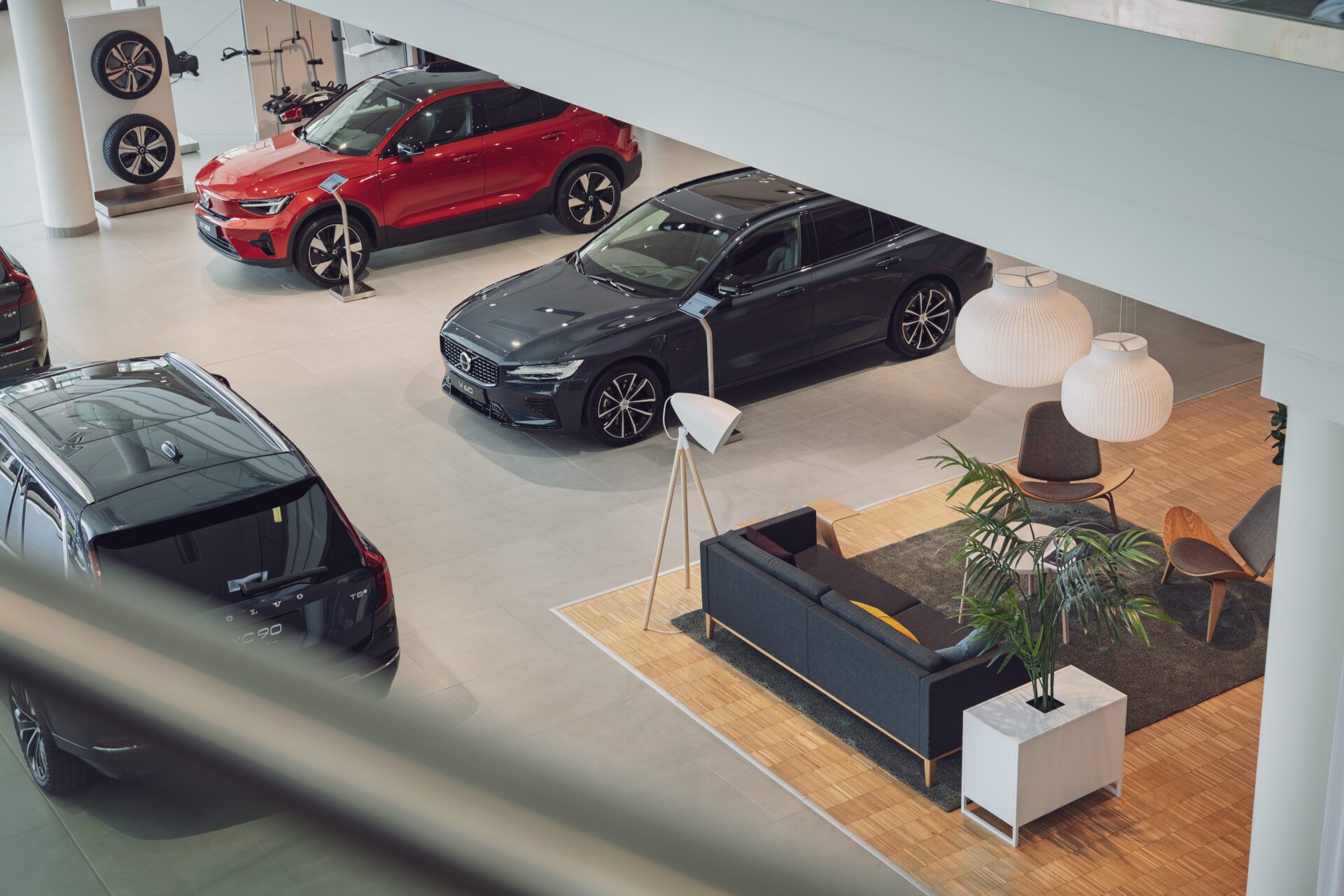 Volvo bilar i en modern och ljus bilhall hos Helmia i Karlstad med en stilfull lounge med mörk soffa och lampor