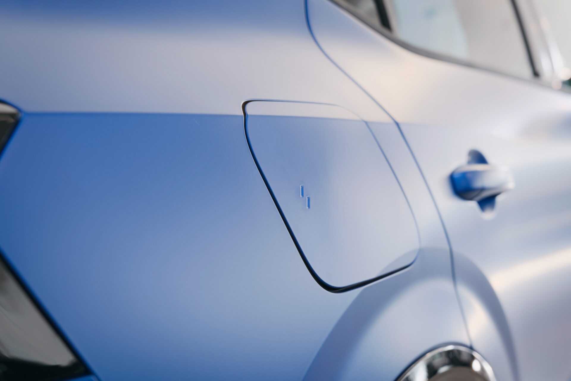 Detaljerad närbild av en blå Renaults sida med fokus på bränsledörr och mjuka kurvor i Helmia Karlstad