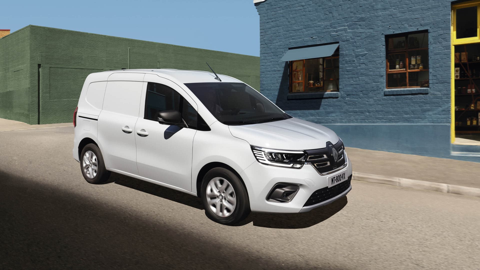 Vit Renault Kangoo E-Tech el-leveransbil parkerad vid färgglada tegelbyggnader i Värmland, under naturligt dagsljus i Helmia i Karlstad