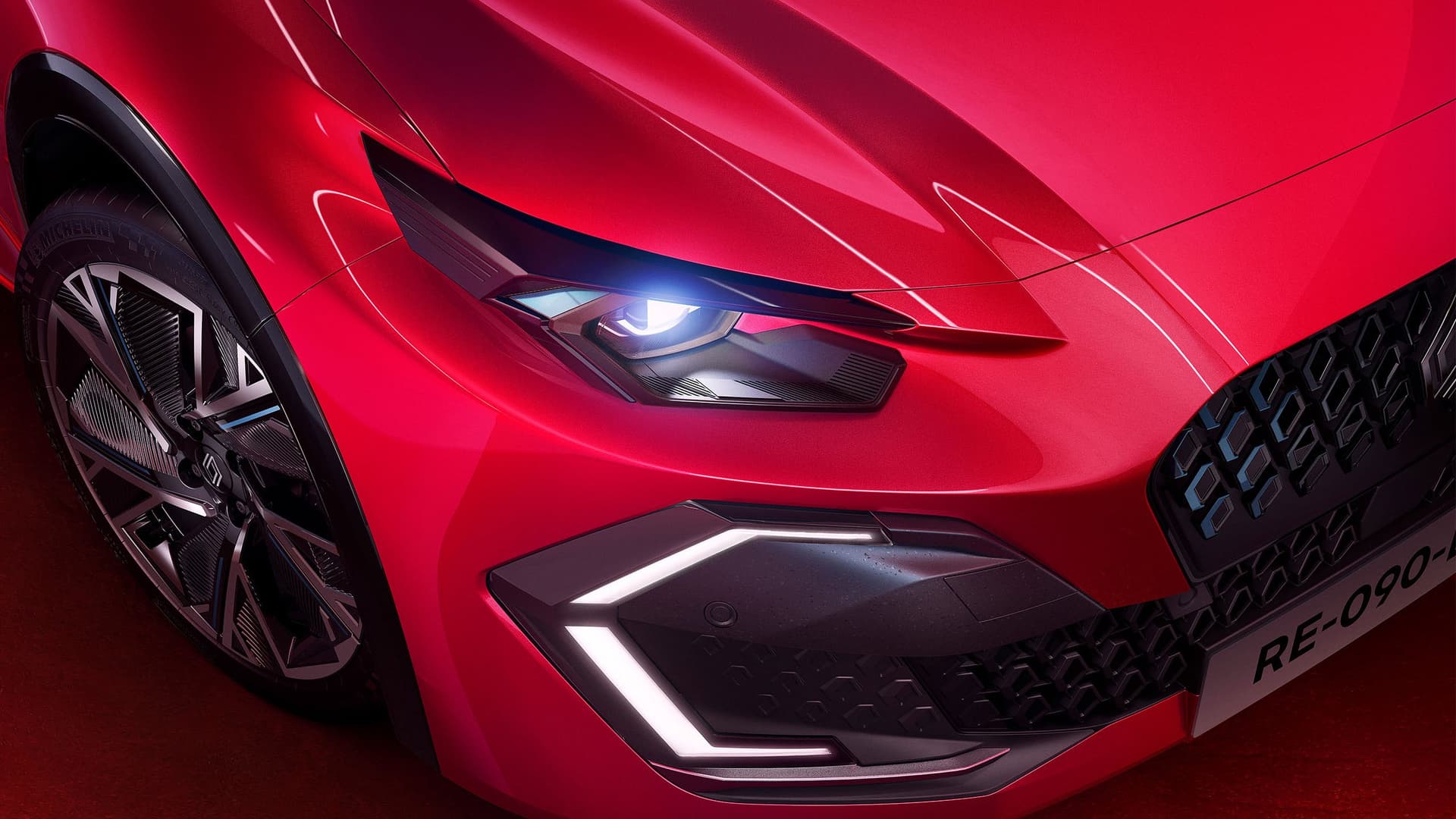 Närbild på röda Renault Clios front med lysande strålkastare och stilren aluminiumfälg i Helmia