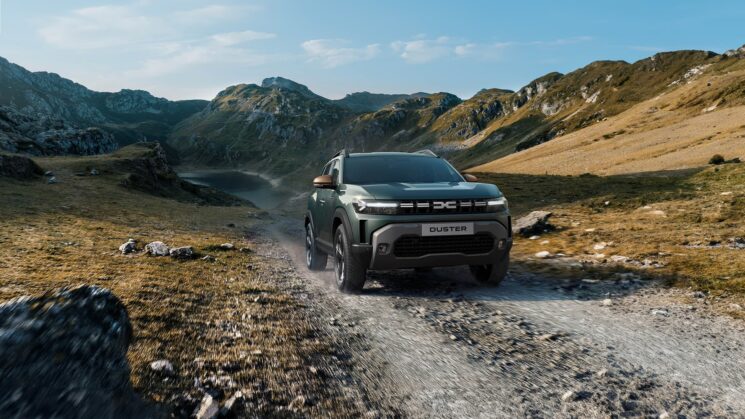 Dacia Duster SUV från Helmia kör på en stenig bergsstig med Värmlands kuperade landskap i bakgrunden och en molnig himmel